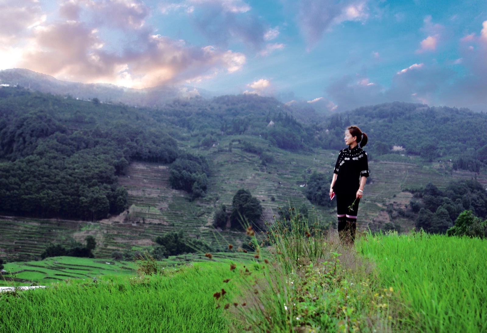 A traveller walking through green rice terraces with a local guide