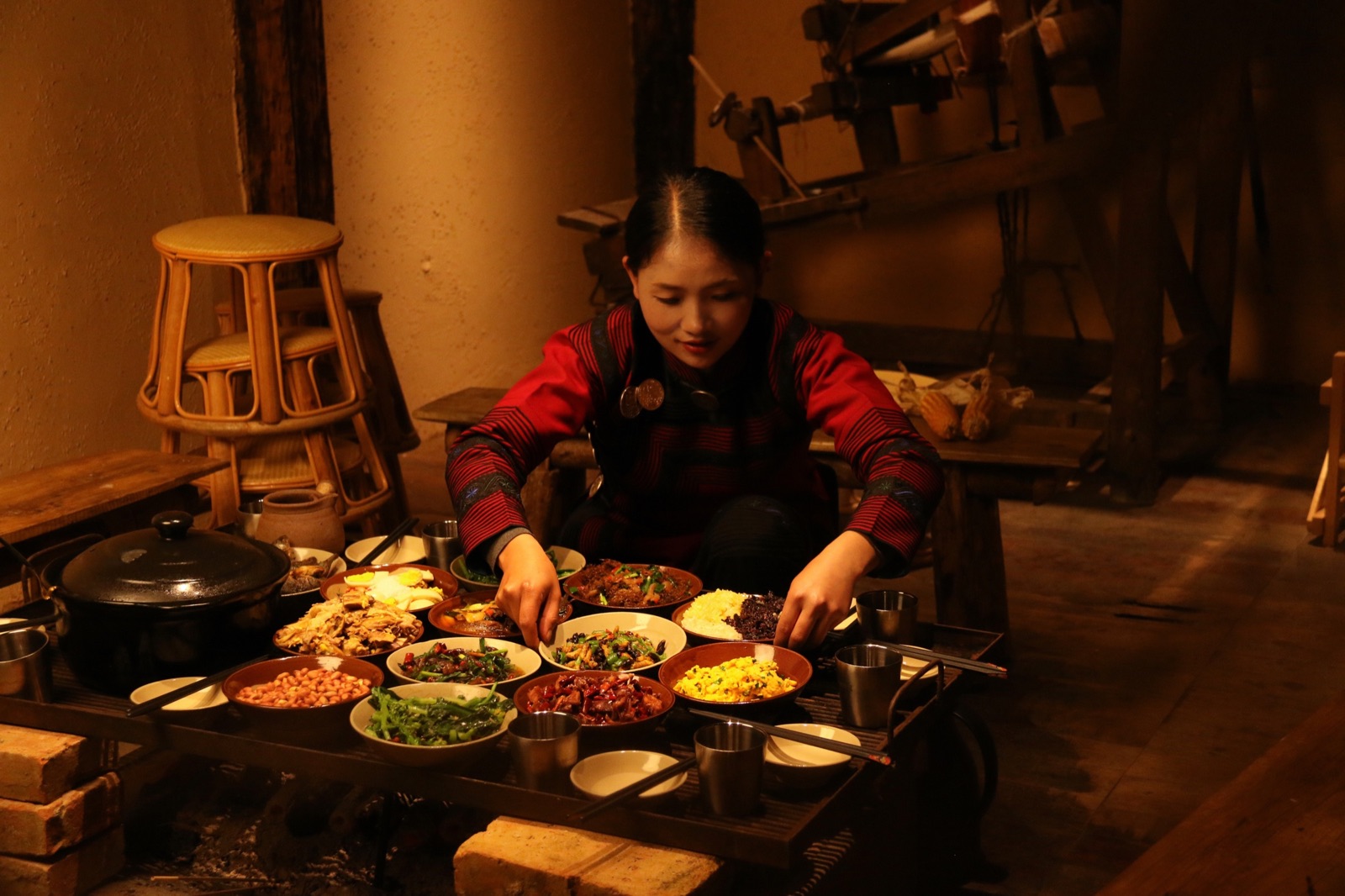 A Hani host preparing a family-style meal beside the hearth