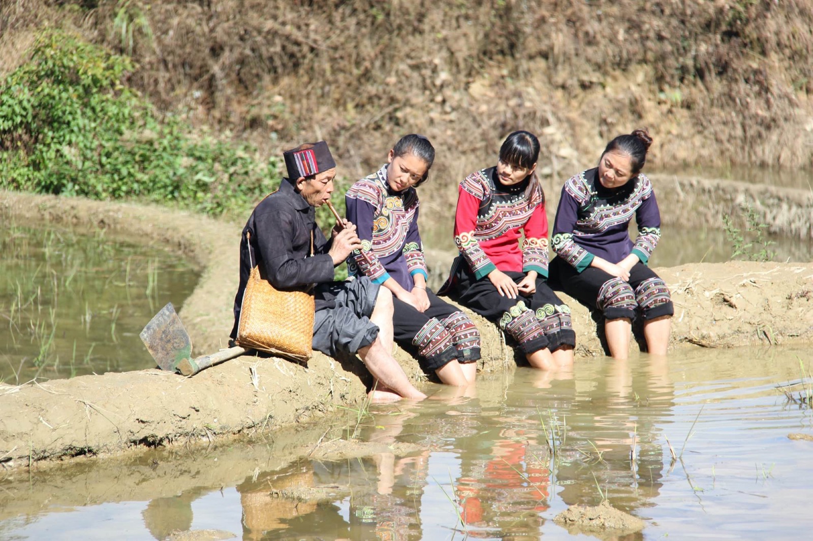 Hani women sharing a cultural activity beside the rice terraces